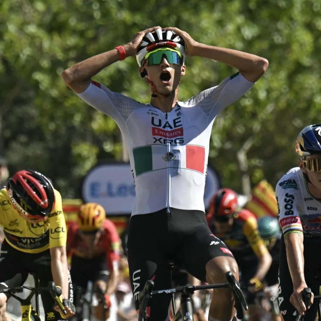 El ciclista mexicano Isaac Del Toro (C), del equipo UAE Team Emirates - XRG, llega a la meta para ganar la segunda etapa por delante del ciclista esloveno Tadej Pogacar (I). Foto AFP